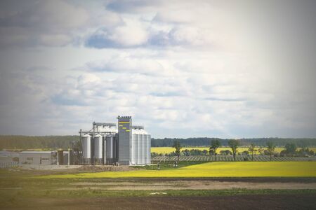 Field of rapeseed flowers, plant for cleaning and storage of agricultural products, flour, cereals and grains.の写真素材