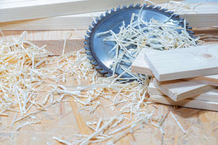 Carpenter tools on wooden table with sawdust. Circular Saw. Carpenter workplace top view.