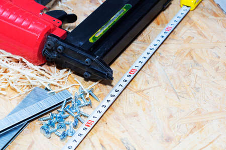 Red pneumatic construction stapler and a stack of staples for the stapler.