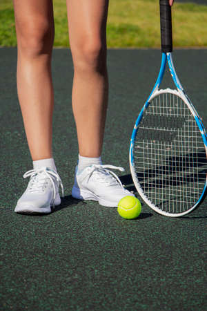 A tennis player with a racket stands on the tennis court. Sport