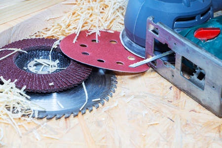 Carpenter tools on wooden table with sawdust. Circular Saw. Carpenter workplace top view.