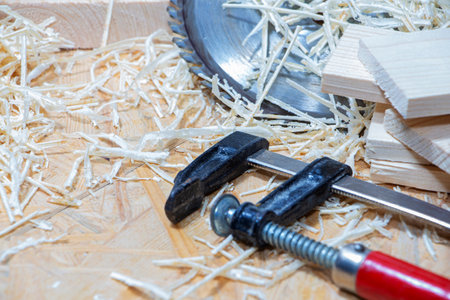 Carpenter tools on wooden table with sawdust. Circular Saw. Carpenter workplace top view.
