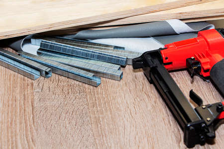 concept of furniture production and repair. Stapler and staples, working tool