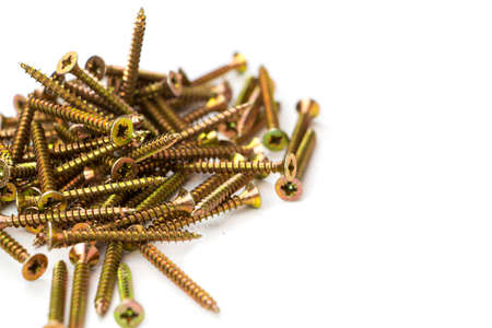 yellow self-tapping screw on a white background. A large number of screws.の写真素材