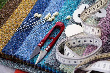 Pieces of cloth with scissors, needle and thread. Tailoring, manufacture of upholstered furniture.