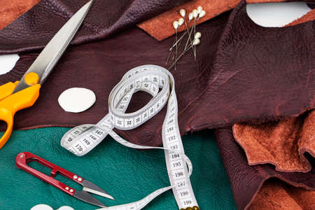 A piece of leather with scissors, needles, chalk,