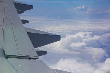 The wing of an airplane flying above the clouds. advertising for travel, air transport