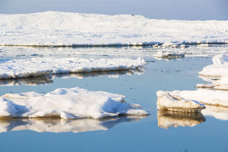 Close-up of a large piece of ice in blue water. Global warming, melting glaciers