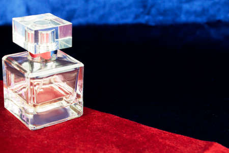 A mock-up of a perfume bottle on a dark background. Side view