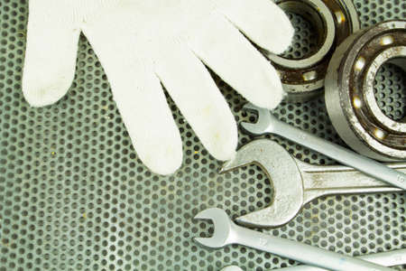 Replacement of the bearing, steel parts, a wrench, on the background of a metal grid. Repair of equipment.の写真素材