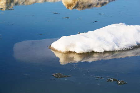 Close-up of a large piece of ice in blue water. Global warming, melting glaciers.