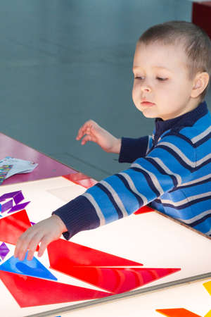 The boy is playing indoors. A gaming experience for young children