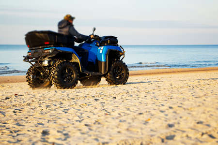 Happy ATV driver on the beach. Active recreation