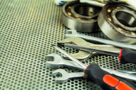Metalworking tools, steel parts, a wrench, on the background of a metal lattice