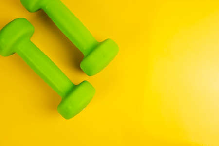 Two dumbbells, on a yellow background, health, diet sportsの写真素材