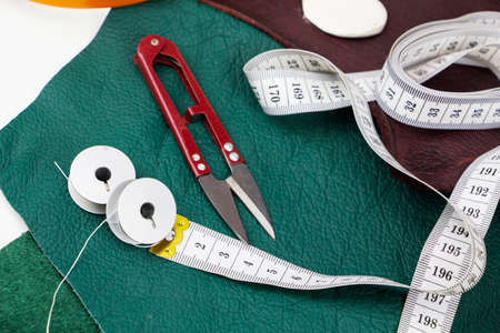 A piece of leather with scissors, needles, chalk,