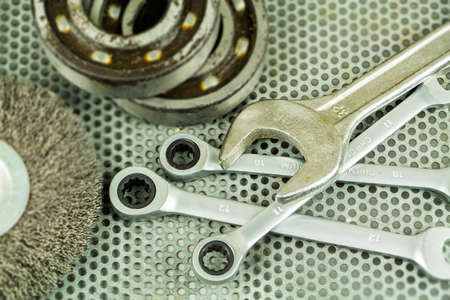 Metalworking tools, steel parts, a wrench, on the background of a metal lattice.の写真素材
