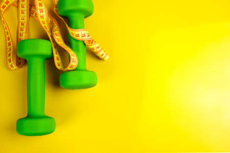 Two dumbbells, on a yellow background, health, diet, sports.の写真素材