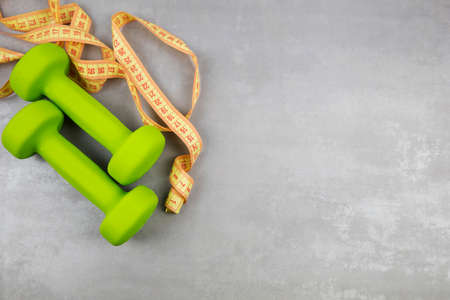 dumbbells, measuring tape on a gray textured background. Fitness, sports nutritionの写真素材