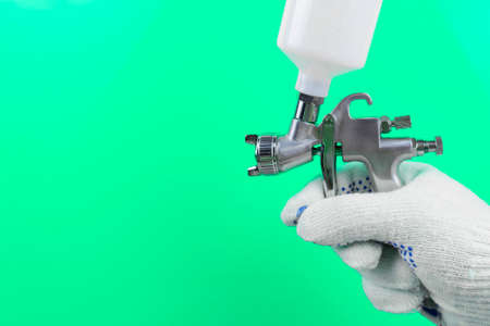 Manual and paint spray gun at work on backgroundの写真素材
