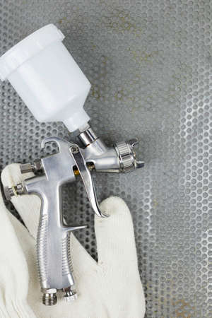 Instructions and a paint spray gun at work at the workplace in the workshop.
