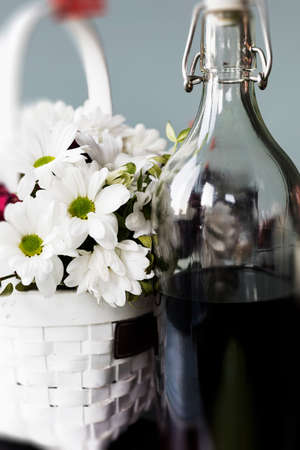 A bottle of red wine. A bottle of wine on a background of white flowers. The concept of a romantic partyの写真素材