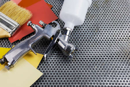 paint spray gun at work at the workplace in the workshop.