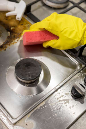 dirty kitchen stove, empty and full bottles of detergents around.の写真素材