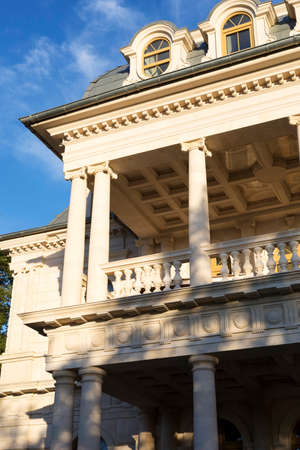 The facade of the house is an old beige building with decorative details.の写真素材