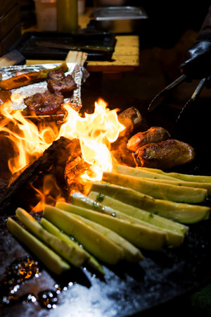 Cooking sausages and grilled vegetables over a campfire. Recreation and summer camping in the...