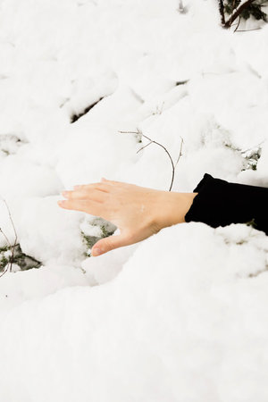 an arm sticking out from under the snow, an avalanche, a snowfall, a disaster.の写真素材