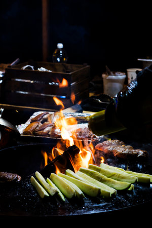 Cooking sausages and grilled vegetables over a campfire. Recreation and summer camping in the...
