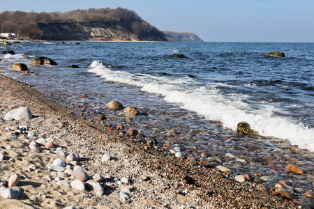 The sea wave beats against a stone on the shore. Blue sea and rocky shoreの写真素材