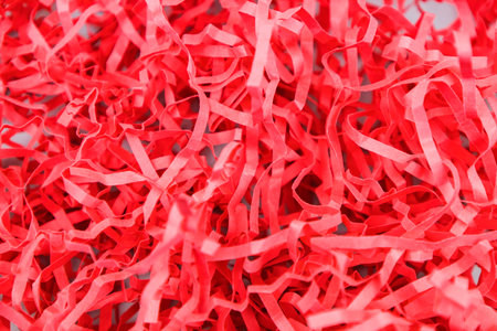 Red paper crumbs for wrapping gifts. View from above. Close-up.