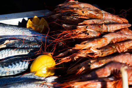 A collection of shrimp is resting on a table right next to a lemon