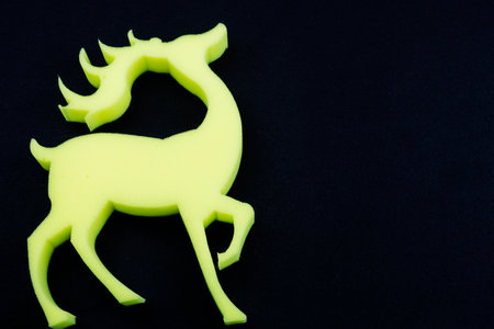 A striking yellow deer with impressive antlers on a black backgroundの写真素材