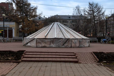 The fountain in the park is covered with a tarp.の写真素材