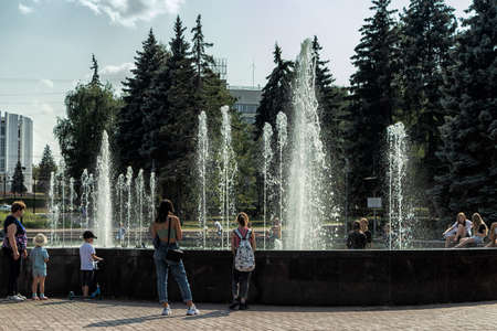 A working fountain and people resting around it.のeditorial素材