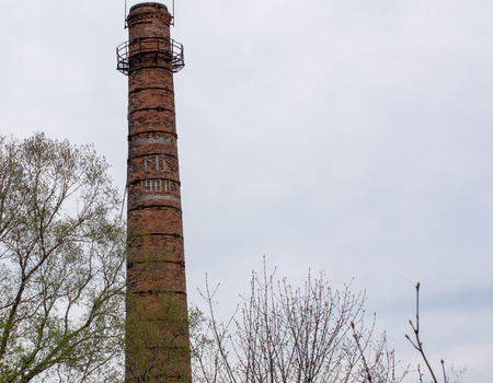 The image of rounded brick chimney on sky background with trees aroundの写真素材