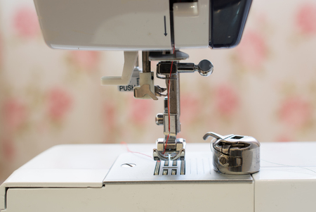 Red needle placed in a white sewing machineの写真素材