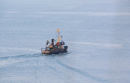 Fishing seiner on extraction of fish swimming in the seaの写真素材