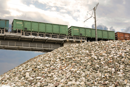 Freight train on the railway bridge. Green railcars on sky background.の写真素材