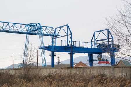 Blue gantry crane with winch over dull sky. Autumn day.の写真素材