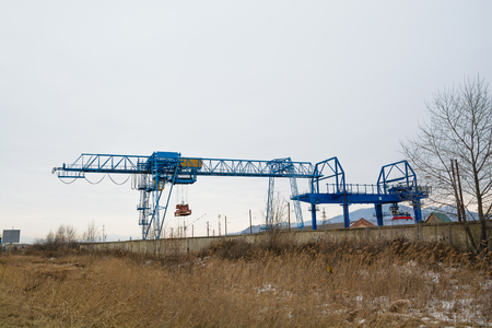 Blue gantry crane with winch over dull sky. Autumn day.の写真素材