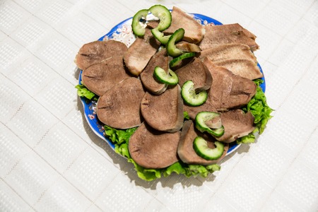 Dish with beef slices and cucumber. The food table