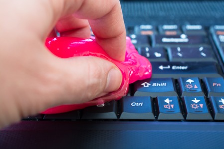 Keyboard cleaning gel in work. Hand and pink gel.の写真素材