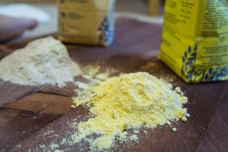 Two Heaps of Different Flour. Yellow One and Grey Another. Two Packages on Background.の写真素材