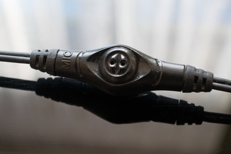 Small Microphone on a Headphone's Wire. Black Wire on the Black Background.の写真素材