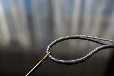 Gray Thread and Needle on the Table. Surface with Reflection.の写真素材