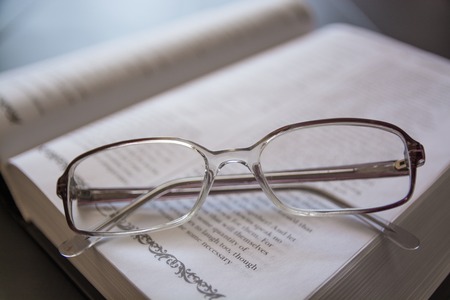 Glasses on the Open Book. Close-Up of White Glasses.の写真素材